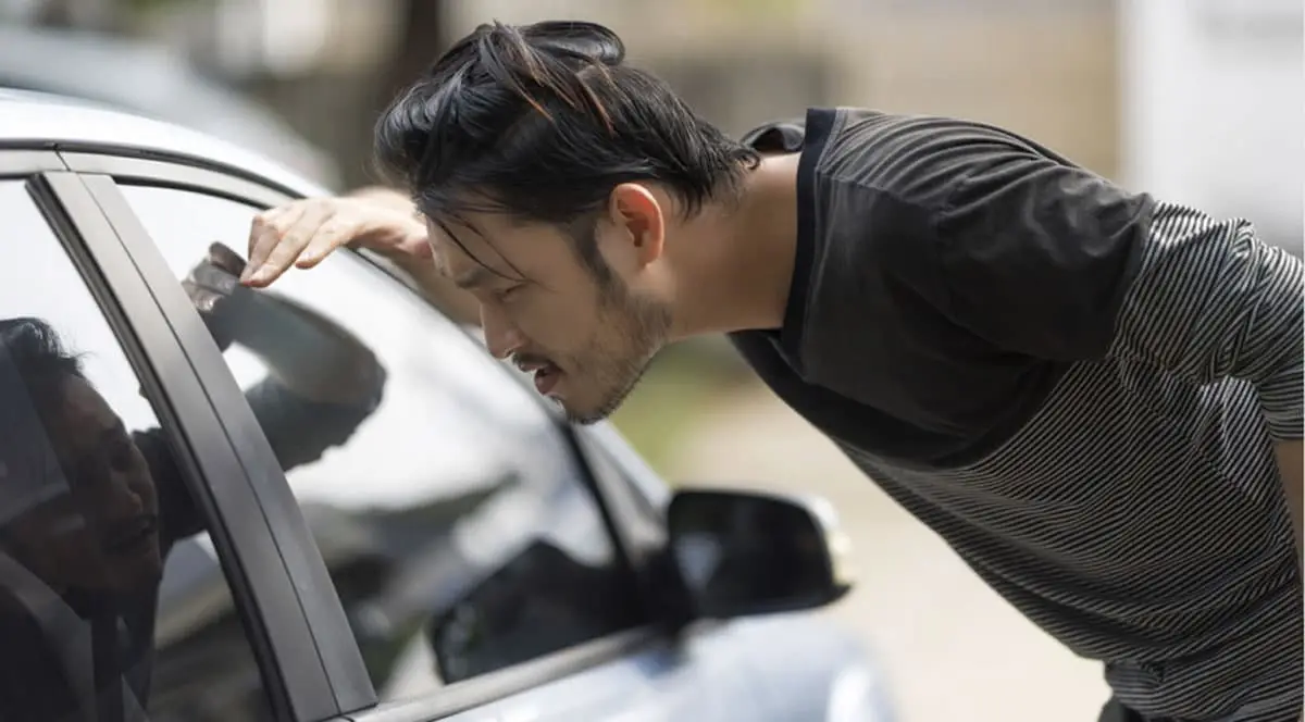 Man locked out of his car waiting for locksmith